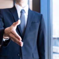 lawyer in business suit extends hand out for handshake