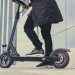 Close up image of a man on an electric scooter