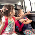 Two children riding in car back seat