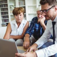 Senior couple planning their investments with financial advisor Senior couple planning their investments with financial advisor