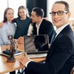 Family lawyer is sitting at table with divorcing family at background.