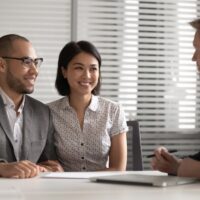 Smiling mixed race family couple meeting real estate agent. Smiling mixed race family couple meeting real estate agent.