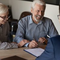 Happy mature family couple of clients consulting legal expert