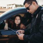 Male cop in uniform checks license of female driver. Law protection, car traffic inspector, safety control job Male cop in uniform checks license of female driver. Law protection, car traffic inspector, safety control job