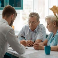 Senior couple taking a risk and making a hard decision while talking with an advisor. Consulting business and retired people.