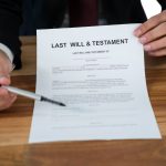 Mid section of businessman showing last will and testament form