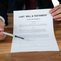 Mid section of businessman showing last will and testament form Mid section of businessman showing last will and testament form